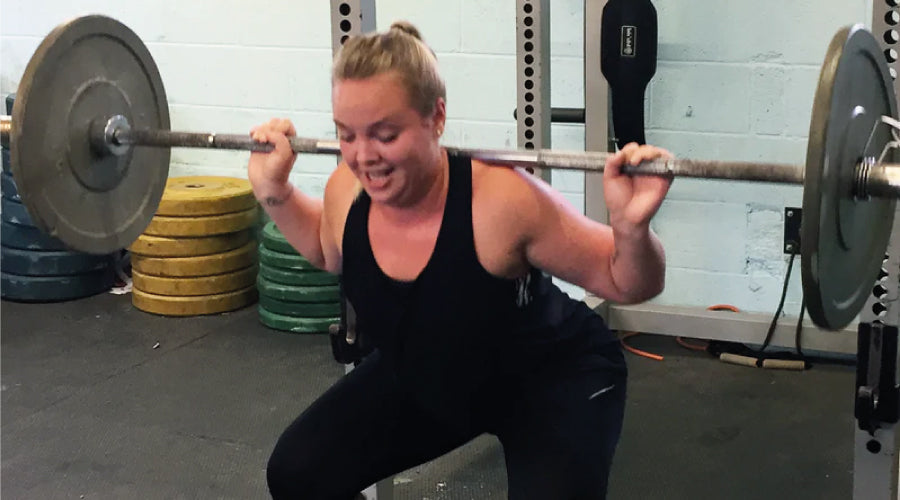 Girl squatting in the gym